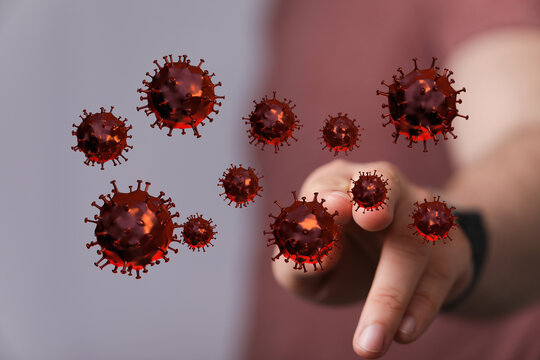 Artistic rendering of a person's hand interacting with virus particles representing concept of health and prev