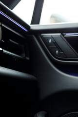 Obraz premium Close-up of a modern car door panel featuring lock controls and ambient lighting. Automotive interior design.