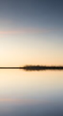 Serene Sunset Reflection Over Calm Lake Water with Distant Horizon and Soft Hues.