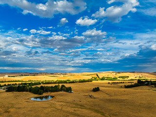 Obraz premium Cloud‑Laced Skies at Golden Hour Over Farmland