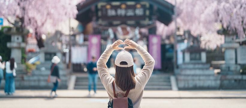 Woman tourist sightseeing Sakurayama Shrine with Cherry blossom in Spring season, happy traveler travel in Morioka city, Iwate prefecture, Japan. famous Landmark Travel and Vacation destination