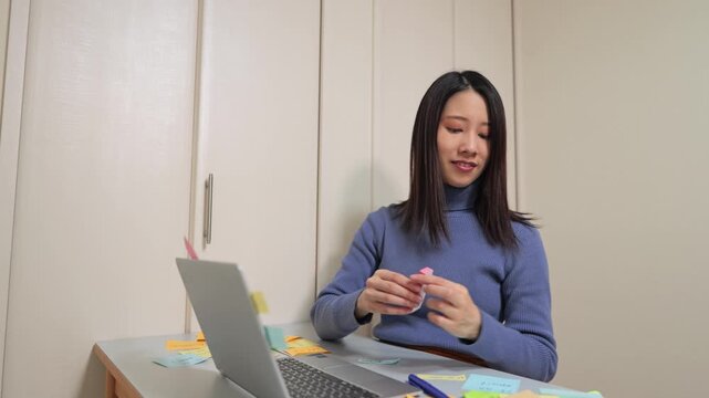 ノートパソコンに付箋をたくさん貼る女性