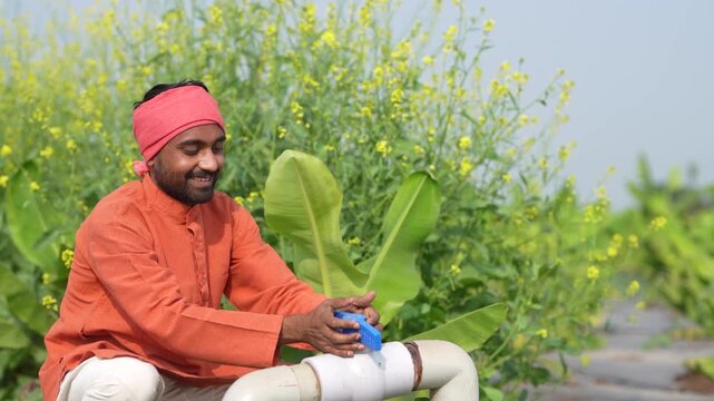 Young indian farmer open water pipe valve at agriculture field 