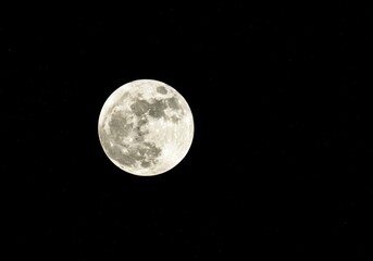 Fototapeta premium Mysterious and luminous full moon orb shining intensely against a dark, cosmic, abstract night sky background, deep blue, natural, indigo