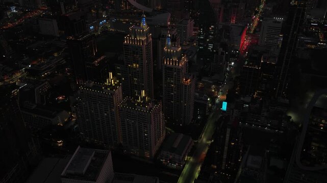 Descending aerial view of an asian cityscape at night