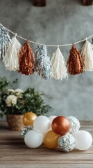 A garland made of foil fringe is displayed above a cluster of balloons. In the background, a basket holds flowers. This scene shows part of a celebration setup indoors
