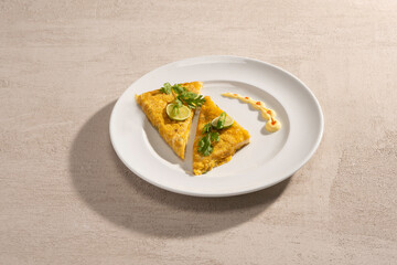 Omelette with cheese and green onion and bacon on plate over light background. Top view.