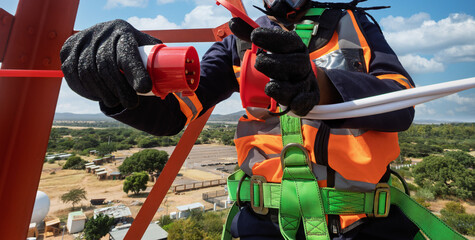 Aerial View of High-Voltage Technician Connecting Power on Telecommunications Tower