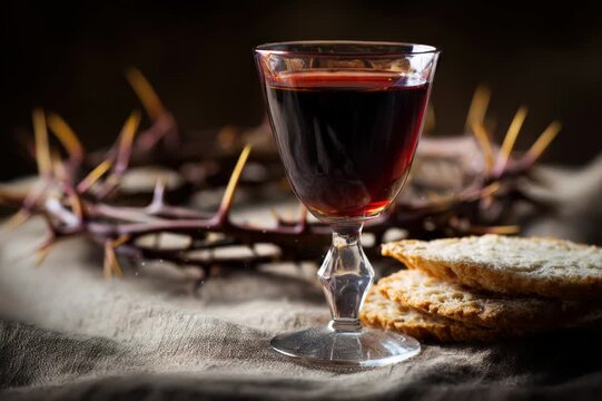 A symbolic depiction of the Holy Communion, with a glass of rich red wine set against a humble crown of thorns and unleavened bread. ..Created with Generative AI, not depicting real subjects.
