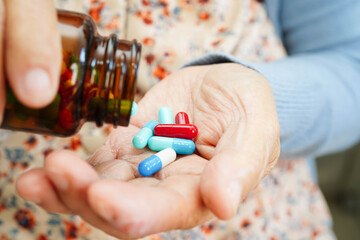 Asian elderly woman holding pill drug in hand, strong healthy medical.