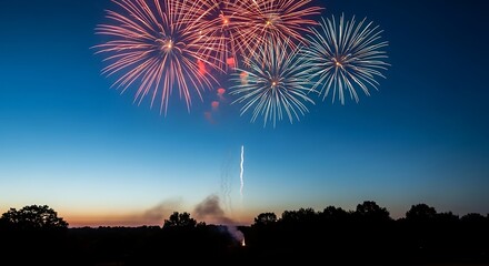 Fireworks display over dark horizon and trees at dusk, with a launching trail
