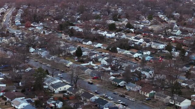 Aerial view of an American suburban neighborhood in winter, showing rows of houses, quiet residential streets, bare trees and calm atmosphere during cold season.