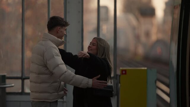 A young couple saying goodbye at a train station in Paris The man is reaching out his hand to the woman who is standing on the train Panning shot of the scene.