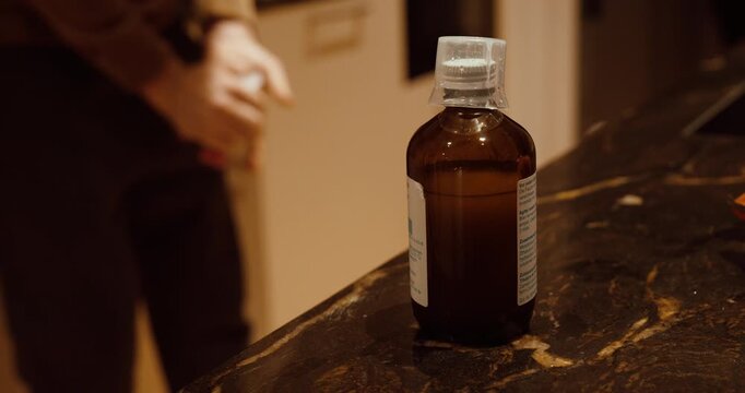 Medicine bottle left behind while a person throws away the package leaflet. Concept of medication misuse, health risk, improper disposal, and pharmaceutical safety awareness.