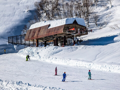 Ski slope scene featuring chairlift terminal and winter sports fans