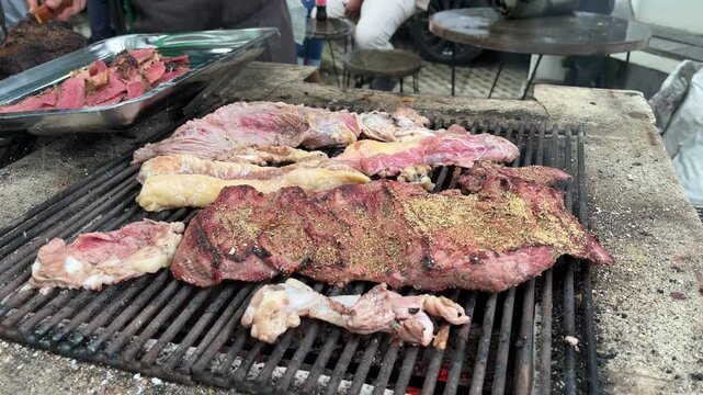 Grilling various beef (Corned beef and texas style) on a steel tray, over charcoal fire