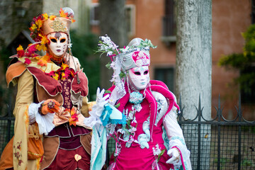 Obraz premium Venice, Italy - February 9, 2026 - People dressed in masks for the Venice Carnival have their photos taken by tourists.
