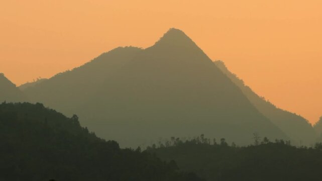 4K wide landscape shot of silhouette mountains during sunset in H&agrave; Giang , Vietnam 