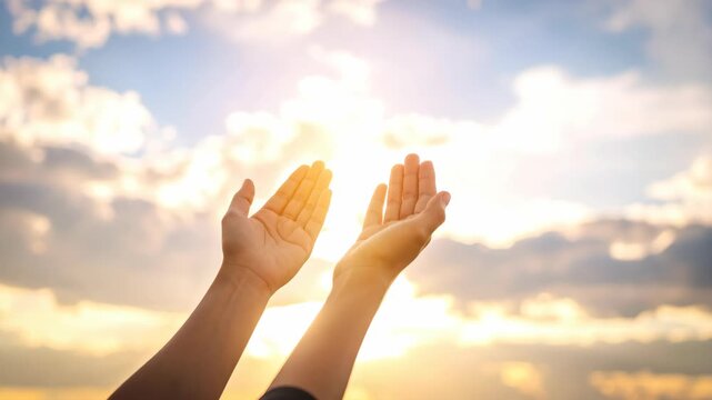 Person raising hands towards bright sun in sky with clouds