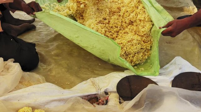 Close-up of preparing murmura ladoo using puffed rice mixed with melted jaggery syrup on a traditional sheet, showing hands, texture, and authentic Indian sweet making.