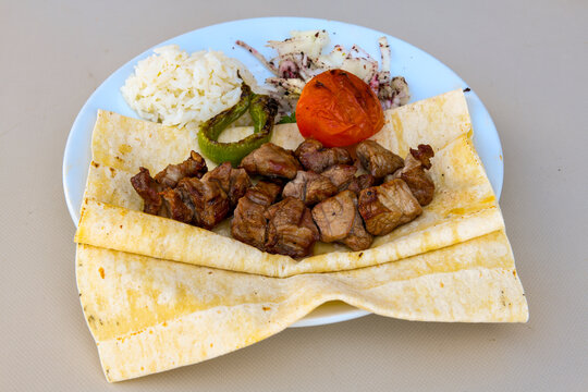 Famous Urfa meat liver, ciger wrapped by lavash with roasted chili pepper, onion and sauce in Sanliurfa, Turkey. Izgara kuzu et sis ciger. Izgara dana bonfile, cop sis, kuzu pirzola. Karisik kebap.
