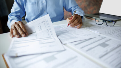 close up shot, accountant working with laptop reviewing the company's accounts and financial documents on desk