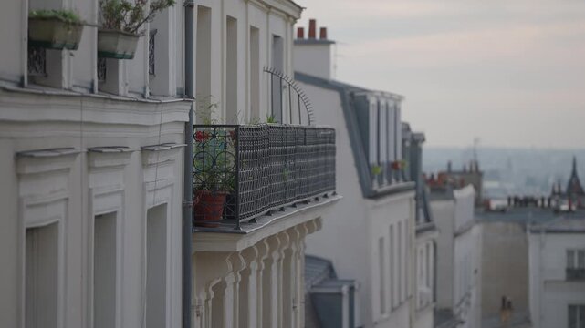 Establishing shot of Paris rooftops and balconies on an overcast day The clip showcases the architecture of the city buildings highlighting a travel destination in Europe The urban scene captures the 