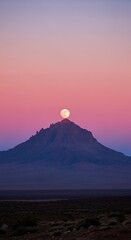 Obraz premium Mountain Peak with Full Moon Rising at Sunset in Desert Landscape