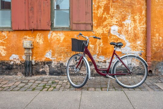 Vintage Bicycle Parked Against Orange Wall in Copenhagen, Nyboder District, Denmark