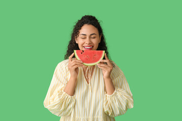 Happy young African-American woman with fresh watermelon on green background