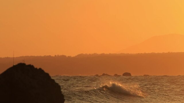 4K wide cinematic sunset b-roll of a silhouette fishing boat sailing during sunset to the harbor in Phan Thiet , Vietnam 