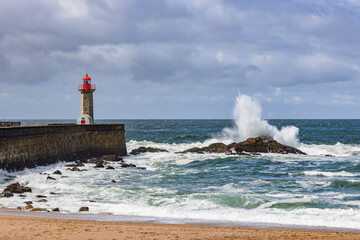 Obraz premium Waves breaking at the Farolim da Barra do Douro, lighthouse in Foz do Douro, Porto, Portugal.