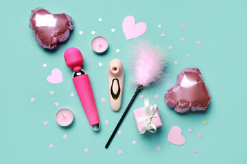 Different sex toys with candles and heart shaped air balloons on blue background. Valentine's Day...