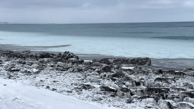 厳冬期のオホーツク海、鉛色の空と海、打ち上げられた流氷