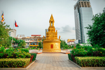 Golden pagoda monument stands against modern glass skyscraper in asian city. © luok