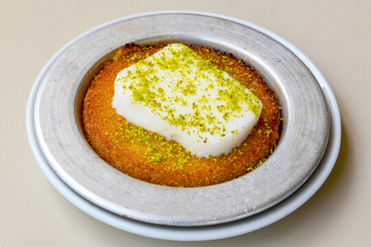 Pistachio kadayif on a plate. Turkish Dessert Kadayif with pistachio powder. Kunefe. Local name burma kadayif