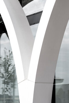 Modern white concrete arch structure showing curve geometry in minimal abstract architecture detail with clean lines and spacious background