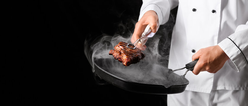 Male chef frying meat on grill pan against black background, closeup
