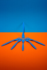 Blue plastic forks on a colored background