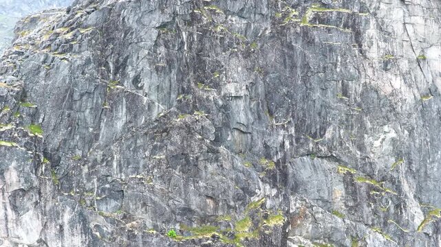Aerial, forward drone flight towards impressive rocky mountain cliff on Barden mountain peak. Amazing wild nature. Senja island in Norway. Beautiful landscape, wild nature.