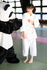 パンダの着ぐるみに体当たりしてタックルする空手着の子供