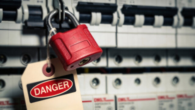 Red lock and danger tag on circuit breaker. Lockout tagout electrical safety procedure. Prevention of accidental startup during repair.