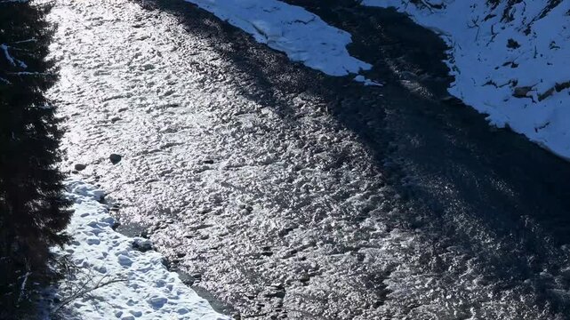 Aerial view of the Inn River flowing through winter landscape near Scuol, Switzerland