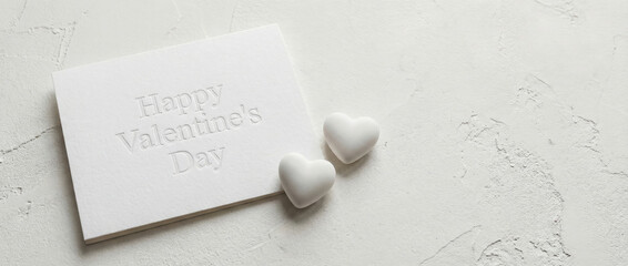 White Happy Valentines Day card with two simple heart shapes. Elegant concept for romantic celebration or affectionate message.