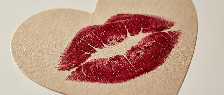 Red kiss print on a heart shape card. Valentines Day love concept for romantic greetings and celebration of affection.