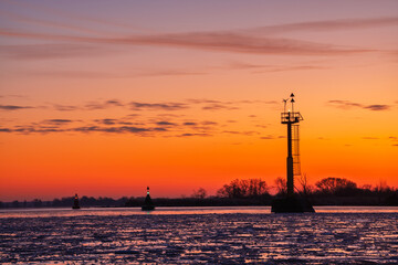 Obraz premium Navigation marks above the frozen fairway leading to the port