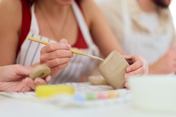 Obraz premium Creative Pottery Workshop: Hands Crafting Clay Bowls Together in a Bright Studio