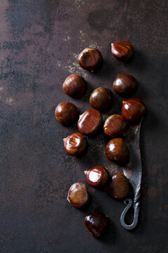 Sweet chestnuts and old knife on rusty ground