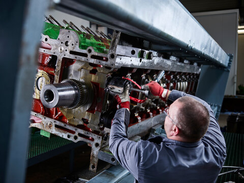 Worker in factory repairing engine block