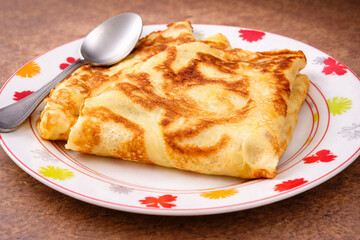Cr&ecirc;pes pli&eacute;es dor&eacute;es sur assiette, dessert traditionnel fran&ccedil;ais